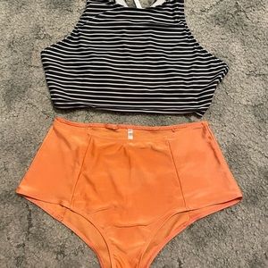 Black and white striped top, crew top, orange high rise bottoms, two piece.
